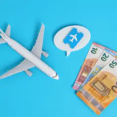 Avión de juguete, billetes de euro y un ticket aéreo. Piensa en cuándo es mejor comprar vuelos para ahorrar.