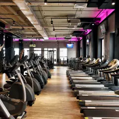 Nowoczesna siłownia z rzędami bieżni i orbitreków. Sprawdź atrakcyjną **Medicover Sport cenę** i zacznij trening!