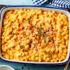 Gratin de pâtes crémeux et doré, garni de fromage râpé et de thym frais.
