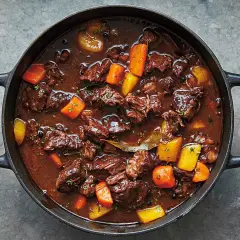 En mustig kalops i gjutjärnsgryta, perfekt för ett klassiskt kalops recept. Kött, morötter och potatis i en mörk sås.
