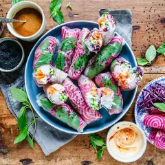 Vackra vietnamesiska vårrullar med kyckling, färska grönsaker och en krämig dippsås. Serveras med en sidoplatta av grönsaker och rödbetor.