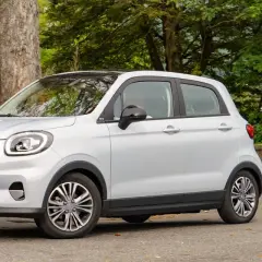Leapmotor T03 usata, un'auto elettrica compatta e agile, parcheggiata in un contesto naturale con alberi e foglie autunnali.