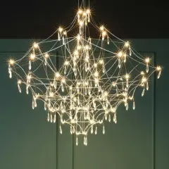 Elegancki żyrandol z kryształkami, przypominający rozgwieżdżone niebo. Każdy klosz emituje ciepłe światło, tworząc magiczną atmosferę.