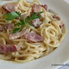 Pyszne spaghetti z boczkiem w kremowym sosie, udekorowane natką pietruszki. Idealne danie dla miłośników włoskiej kuchni.