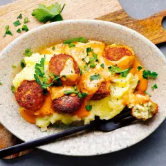 Vegetarische Bällchen auf Kartoffelbrei mit cremiger Sauce, garniert mit Petersilie. Perfekt für schnelle vegetarische Rezepte.