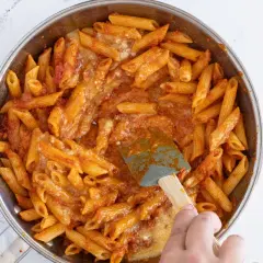 Macarrones con huevo y salsa de tomate en sartén, listos para servir.