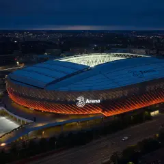 Tele2 Arena i Stockholm lyser upp natthimlen med sitt orangea sken. En ikonisk plats för evenemang.