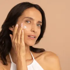 Une femme applique une crème hydratante pour lutter contre la peau sèche.