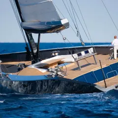 Il Wally Esense naviga con vele spiegate, un uomo al timone. Lusso e velocità sull'onda blu.