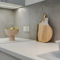 Nowoczesna kuchnia z białym blatem, misą z cytrynami i drewnianymi deskami. Zastanawiasz się, ile kosztuje metr blatu kuchennego?