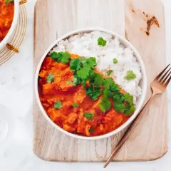 Pyszny kurczak w sosie curry z ryżem, udekorowany świeżą kolendrą. Prosty przepis na szybki obiad.