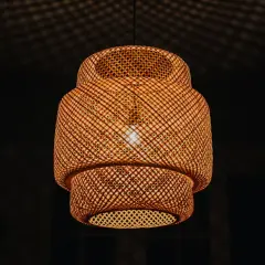 Pleciona, bambusowa lampa ruchoma rzuca na sufit cień przypominający siatkę.