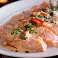 Laxfiléer i krämig hummersås, toppad med färska örter och hummerbitar. En lyxig rätt som passar perfekt för en speciell middag.