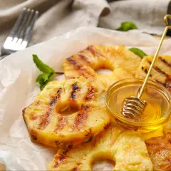 Złocisty, grillowany ananas z miodem i miętą, gotowy do podania.
