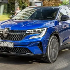 Błękitny Renault Austral pędzi po drodze, jego nowoczesny design i sportowy charakter przyciągają wzrok.