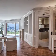 Soggiorno elegante con camino, divani, vista panoramica e cucina moderna. Le pareti in cartongesso effetto legno creano un'atmosfera calda e accogliente.