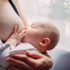 Un neonato si nutre al seno. Scopri come aumentare il latte materno in modo naturale per il benessere del tuo bambino.