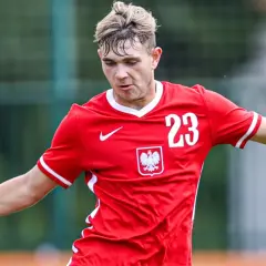 Piłkarz Rakowa w czerwonej koszulce z numerem 23 i godłem Polski, gotowy do gry w Lidze Europy.
