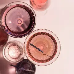 Różowe drinki w kieliszkach, jeden z gałązką lawendy. Idealny szłeps na letnie popołudnie.