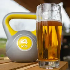 Kettlebell 4kg i szklanka złocistego napoju. Czy piwo bezalkoholowe nawadnia po treningu?