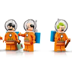 Fünf Lego-Figuren in orangefarbenen Raumanzügen mit Helmen. Sie erinnern an Tim und Struppi auf dem Mond.
