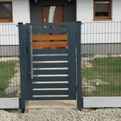 Nowoczesna furtka z metalu i drewna, osadzona na betonowym łączniku podmurówki.