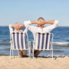 Para seniorów cieszy się wczasy nad morzem z dojazdem z Katowic, relaksując się na plaży.