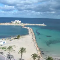 Piękna plaża i turkusowe morze w Tunezji. Październikowa pogoda idealna na spacer brzegiem.