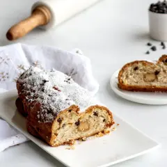 Un délicieux gâteau de Noël, saupoudré de sucre glace, semble avoir été volé, avec une part coupée et servie sur une assiette.