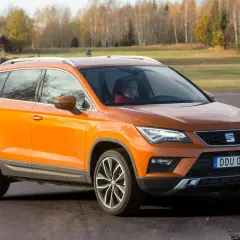 Orange Seat Ateca på en grusväg, redo för ett test. En förare sitter bakom ratten.