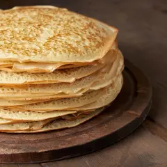 En hög med gyllene pannkakor med havregryn, perfekt för en mysig frukost eller fika.