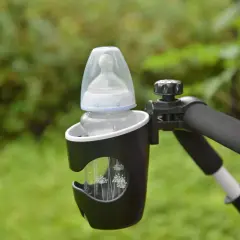 En nappflaska i en svart mugghållare fäst vid ett barnvagnshandtag. Kaxholmen babysitter-tillbehör för bekväma promenader.