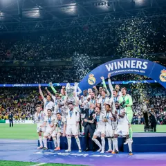 Piłkarze Realu Madryt świętują zwycięstwo w Lidze Mistrzów 2024, podnosząc trofeum wśród konfetti.