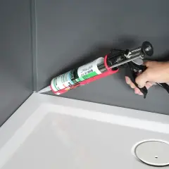 Aplikacja silikonu sanitarnego neutralnego w narożniku brodzika prysznicowego.