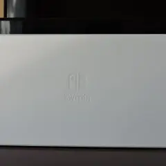 Biała konsola Nintendo Switch z dokiem do podłączenia do TV.