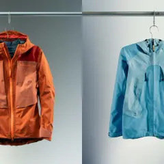 Deux vestes, une orange et une bleue, suspendues. La veste orange est mouillée, montrant l'efficacité du Gore-Tex.