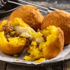 Arancini ripieni di carne e formaggio filante, un esempio di come si fanno gli arancini siciliani, dorati e croccanti.