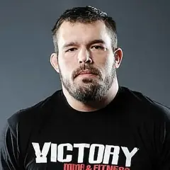 Dean Lister, en tuff MMA-fighter med skägg och en svart t-shirt med texten "Victory MMA & Fitness".