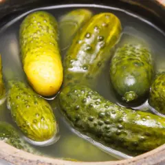 Ogórki kiszone w zalewie w glinianym naczyniu.