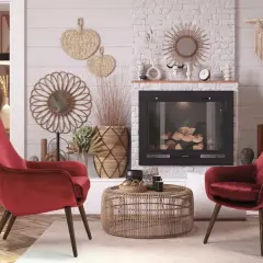 Due poltrone in velluto rosso palissandro, un tavolino in rattan e un camino creano un angolo accogliente.