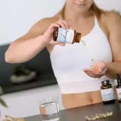 Frau nimmt Omega-3-Kapseln ein, um ihr Wohlbefinden zu fördern.