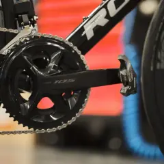 Czarna korba Shimano 105 z rowerowym łańcuchem i pedałem. Gotowa do jazdy po szosie.