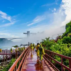 Spacerem po drewnianych kładkach podziwiamy potęgę wodospadu Niagara. W oddali widać most i wieżę widokową.