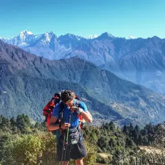Mężczyzna z plecakiem i kijkami podczas trekking w himalajach. Majestatyczne góry w tle.