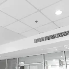 Soffitto modulare bianco con faretti, bocchette di ventilazione e un sistema di controsoffitto autoportante che nasconde gli impianti.