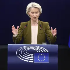 Ursula von der Leyen przemawia przy mównicy z logo Parlamentu Europejskiego i flagą UE.