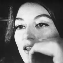 Nahaufnahme von Anouk Aimée, deren Blick nachdenklich ist. Sie erinnert an eine vergangene Liebe, vielleicht ihren Ehepartner.