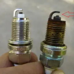 Una bujía nueva y otra desgastada, con óxido y el electrodo doblado. Así puedes saber si las bujías están mal.