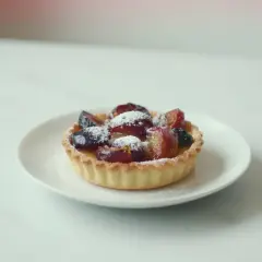 Szybkie ciasto z airfryer: krucha babeczka z owocami i cukrem pudrem, idealna na deser.