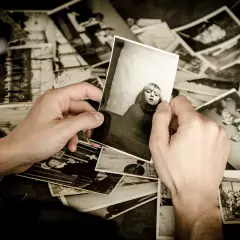 Ręce przeglądają stare fotografie, wspominając przeszłość. To piękny sposób na przechowywanie zdjęć i wspomnień.